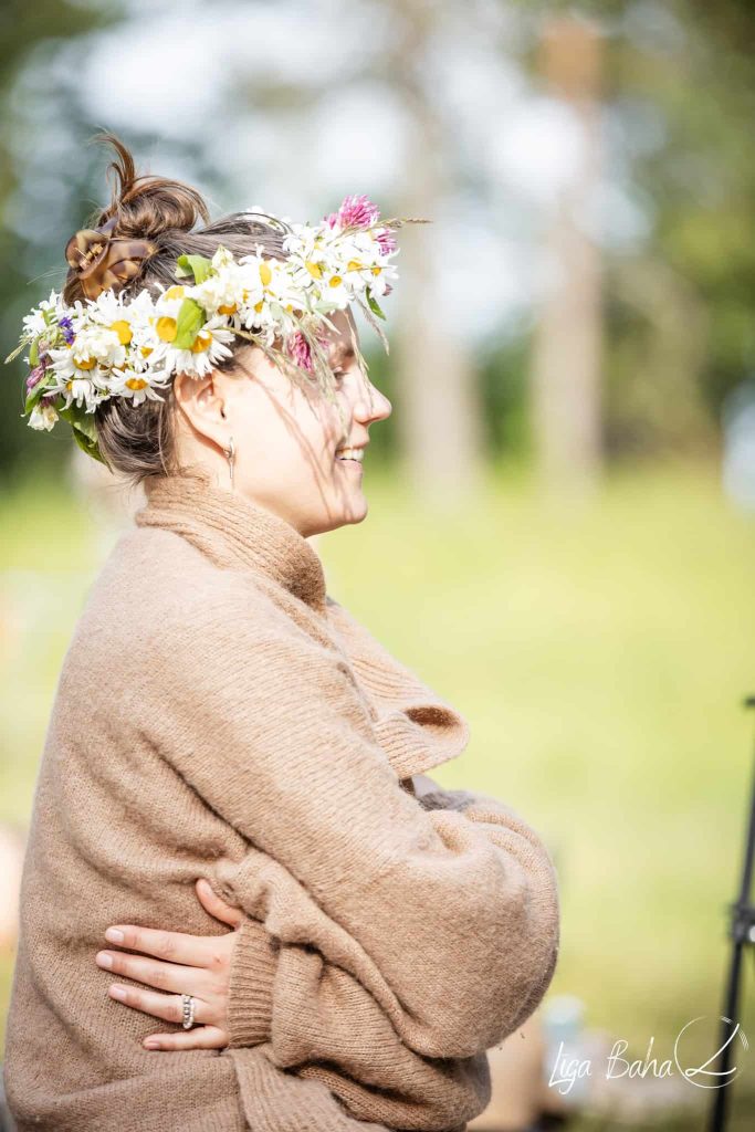 Festivāla dalībnieki ar tradicionālajiem ziedu vainagiem.