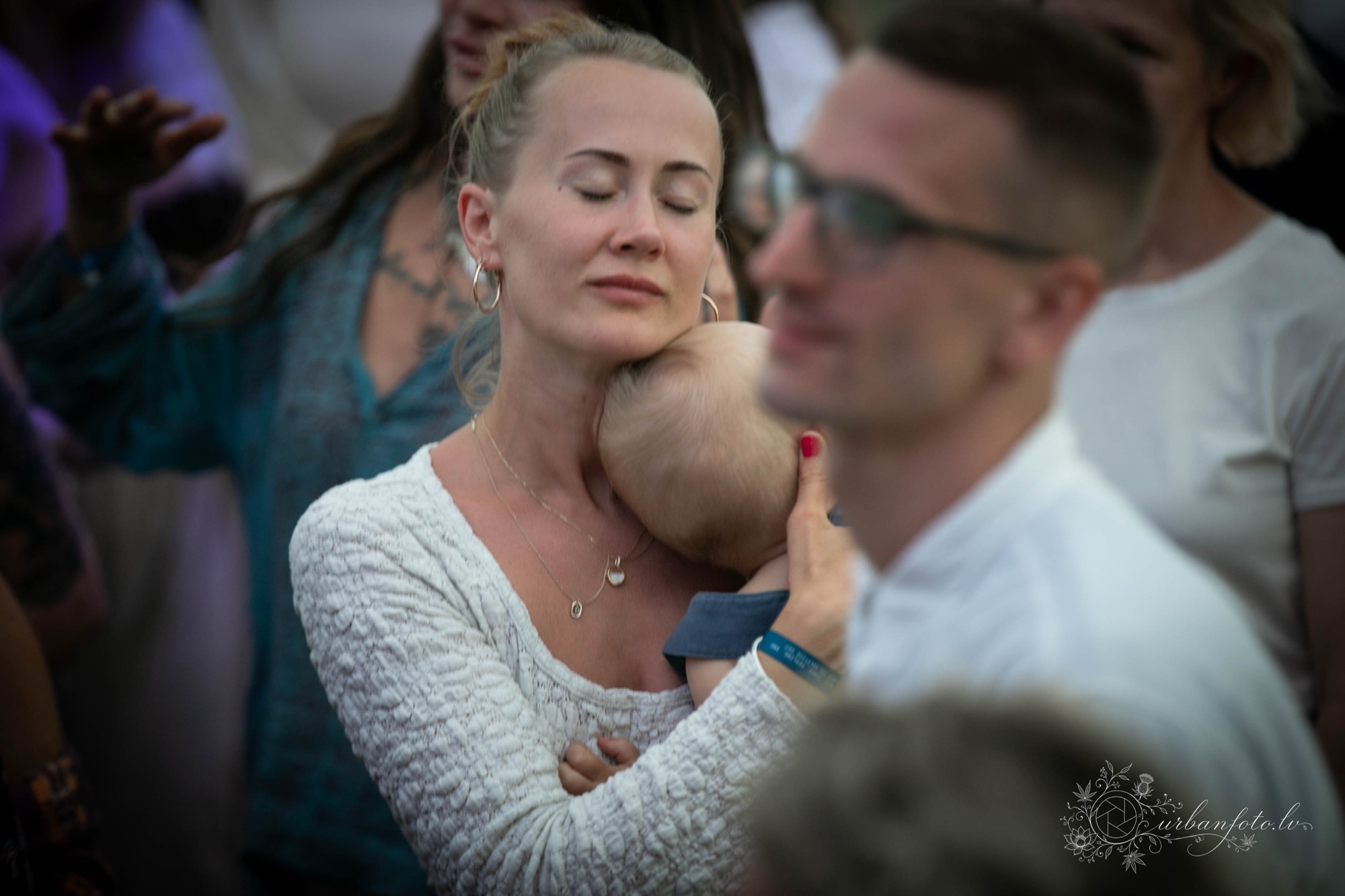 Māte samīļo mazuli BŪTĪBA festivālā 2026 — sirsnīgs ģimenes mirklis vasaras saulgriežu un Jāņu svinībās Latvijā. Ģimenēm draudzīgs festivāls dabā.