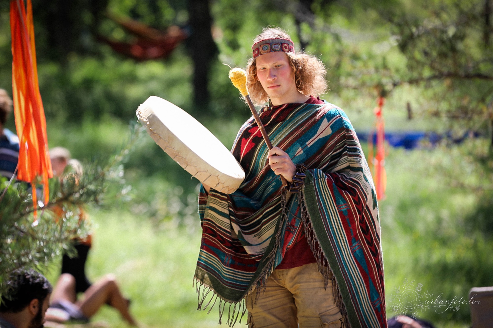 Festival participant playing a large frame drum during a nature-inspired gathering at BŪTĪBA Festival 2026