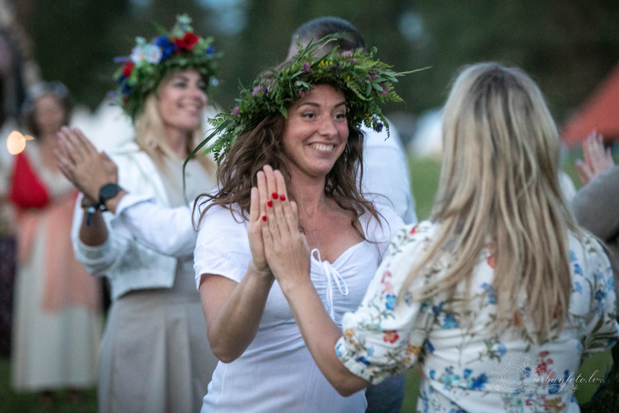 Divas sievietes lapu vainagos dejo rotaļu dejas festivālā Būtība 2026