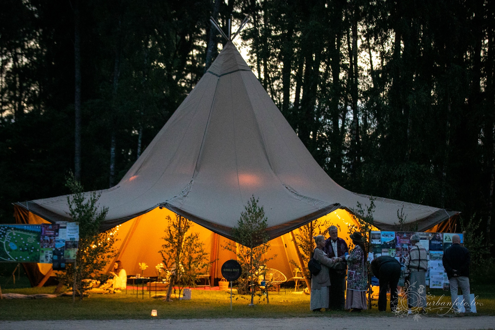 Illuminated festival tent glowing warmly among the trees at night at BŪTĪBA Festival 2026