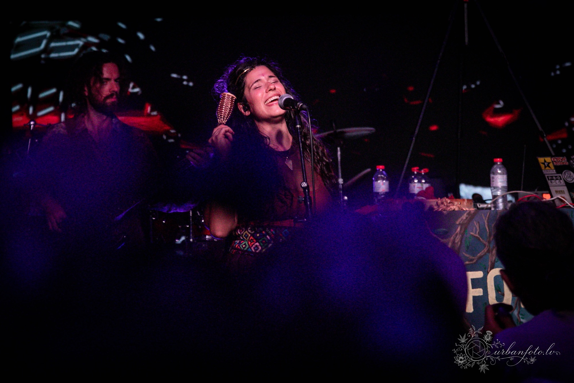 La Forasteria vocalist singing with passion into the microphone during an electrifying BŪTĪBA Festival 2026 night performance. 🎤🔥
