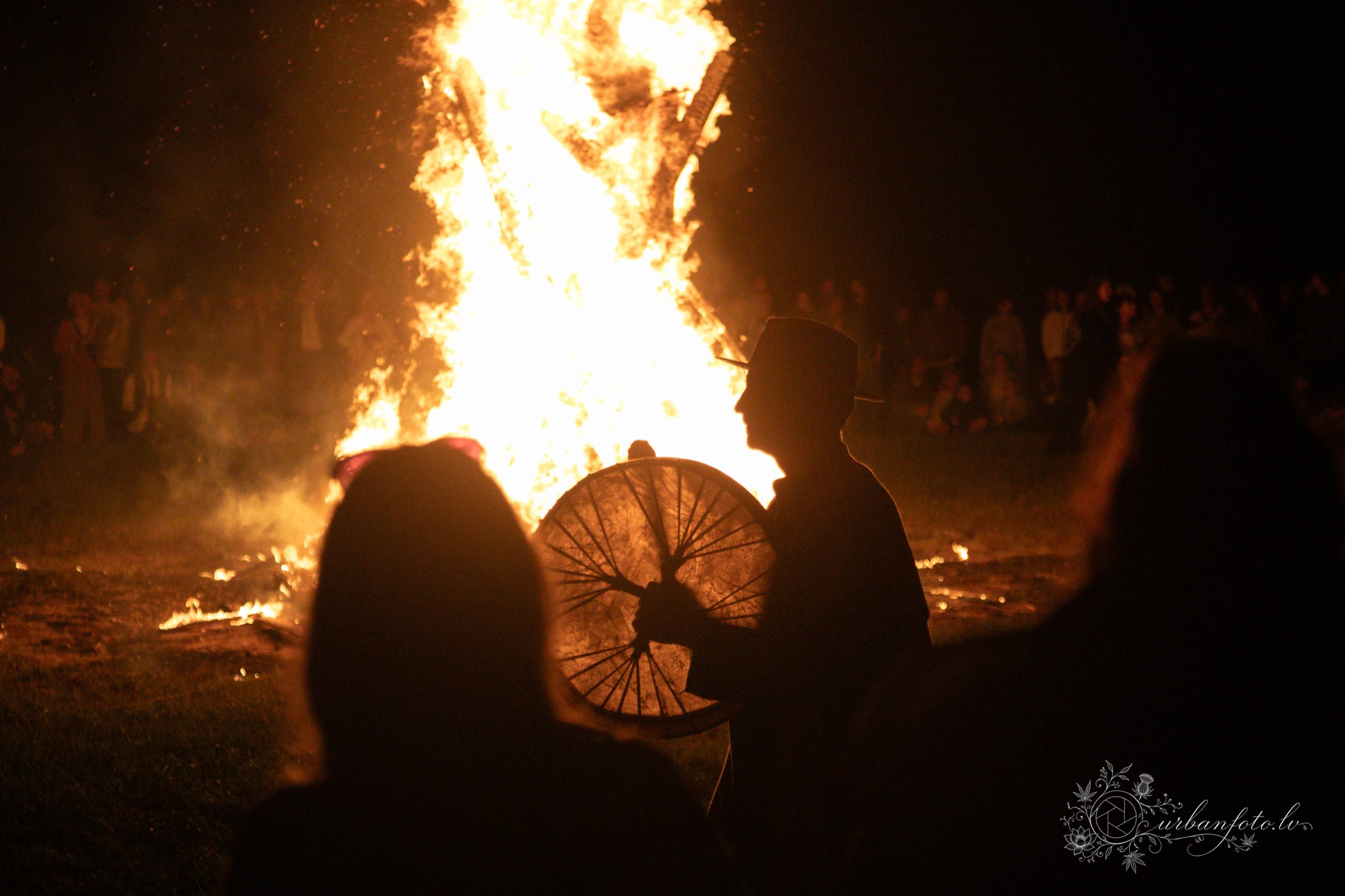 Festival-goers gathered around a large bonfire with a drummer at BŪTĪBA Festival