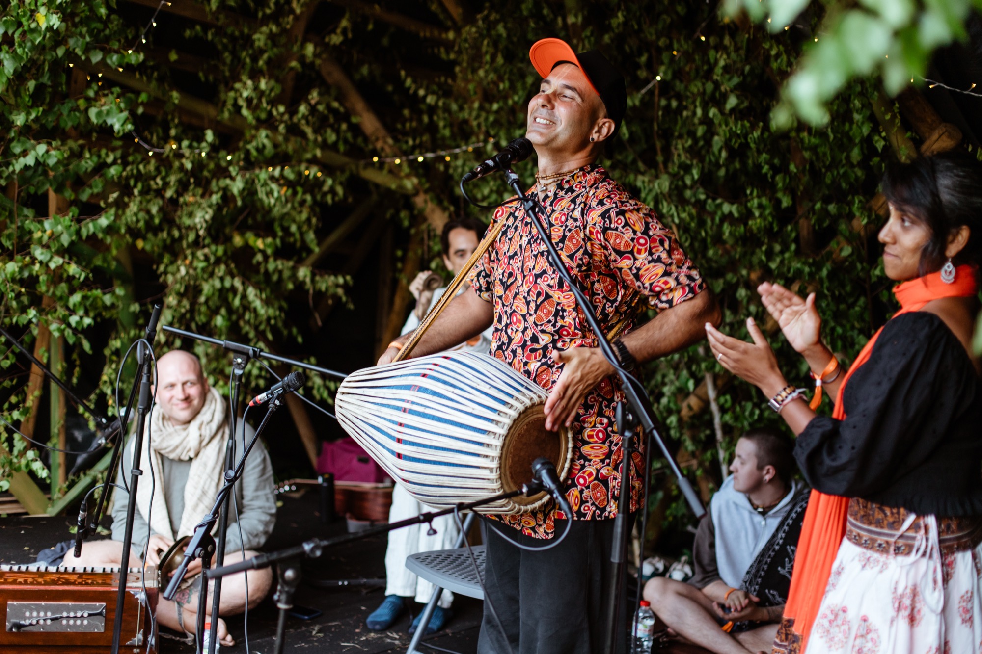 A joyful kirtan session at BŪTĪBA Festival 2026, with a musician playing the mridanga drum and leading the gathering in devotional song.