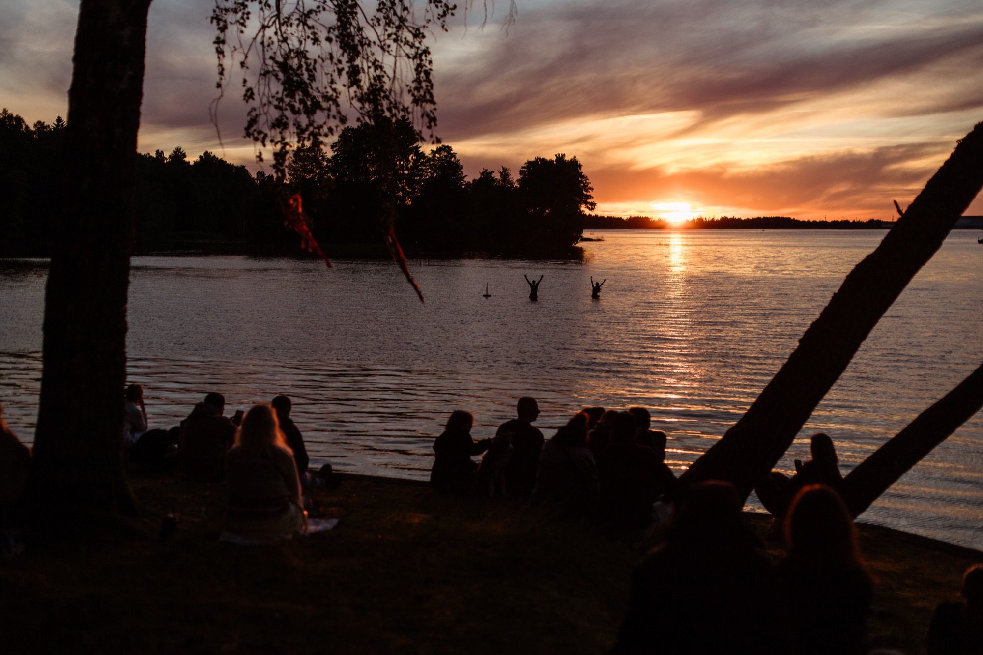 Festival-goers watching the sunset over the Daugava River at BŪTĪBA Festival