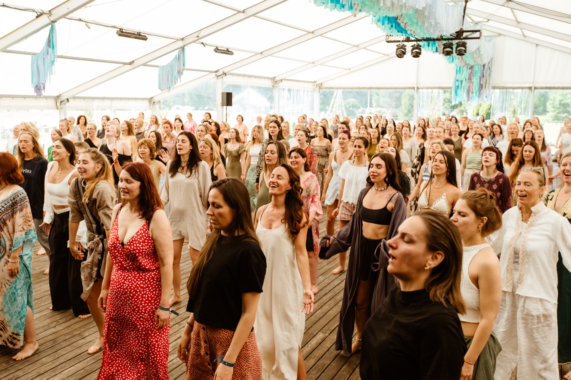 A group of festival participants smiling and moving together during a guided dance and movement workshop at BŪTĪBA Festival 2026
