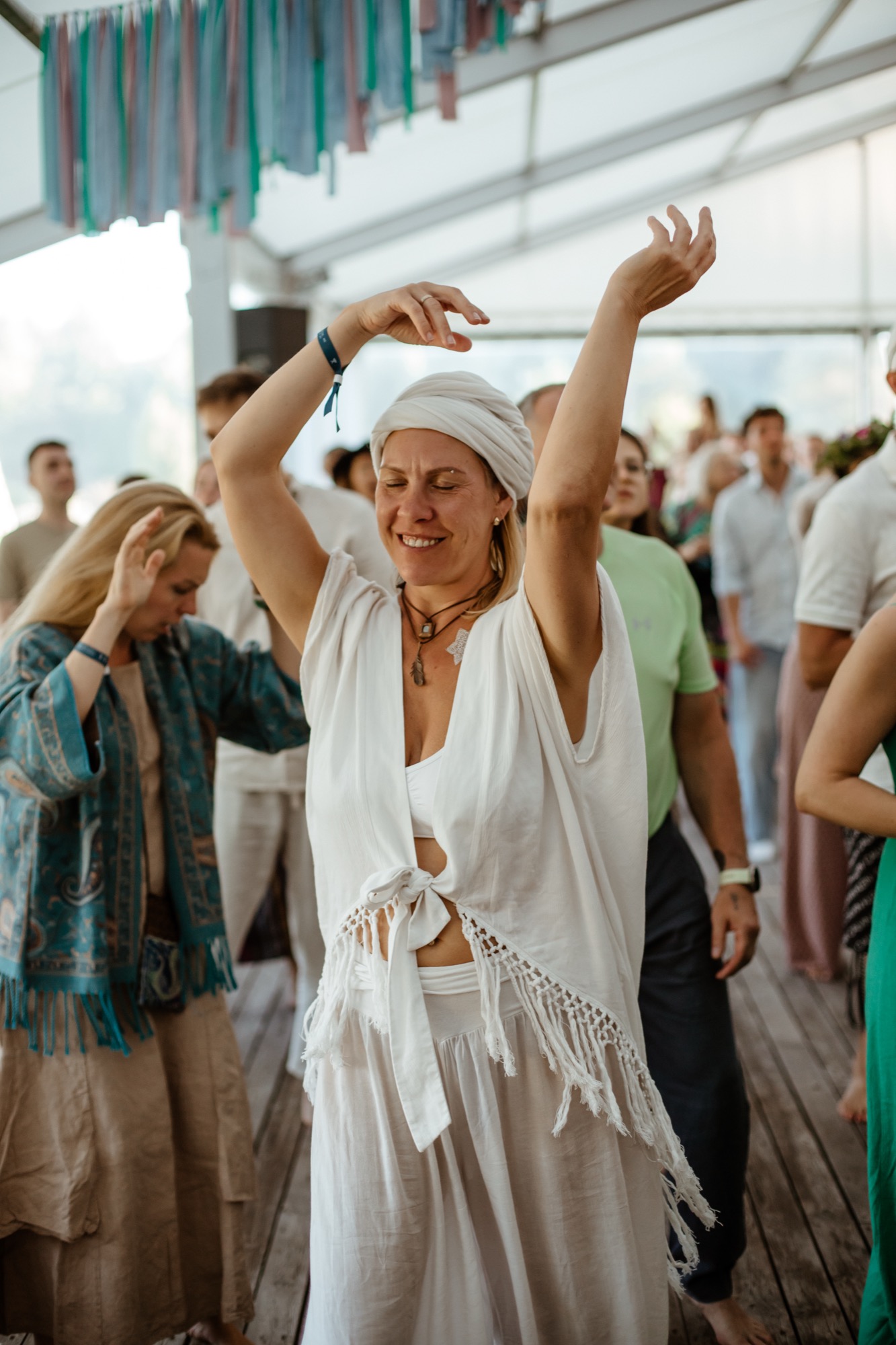 Festivāla dalībniece ar paceltām rokām iegrimst dejā BŪTĪBA festivālā.