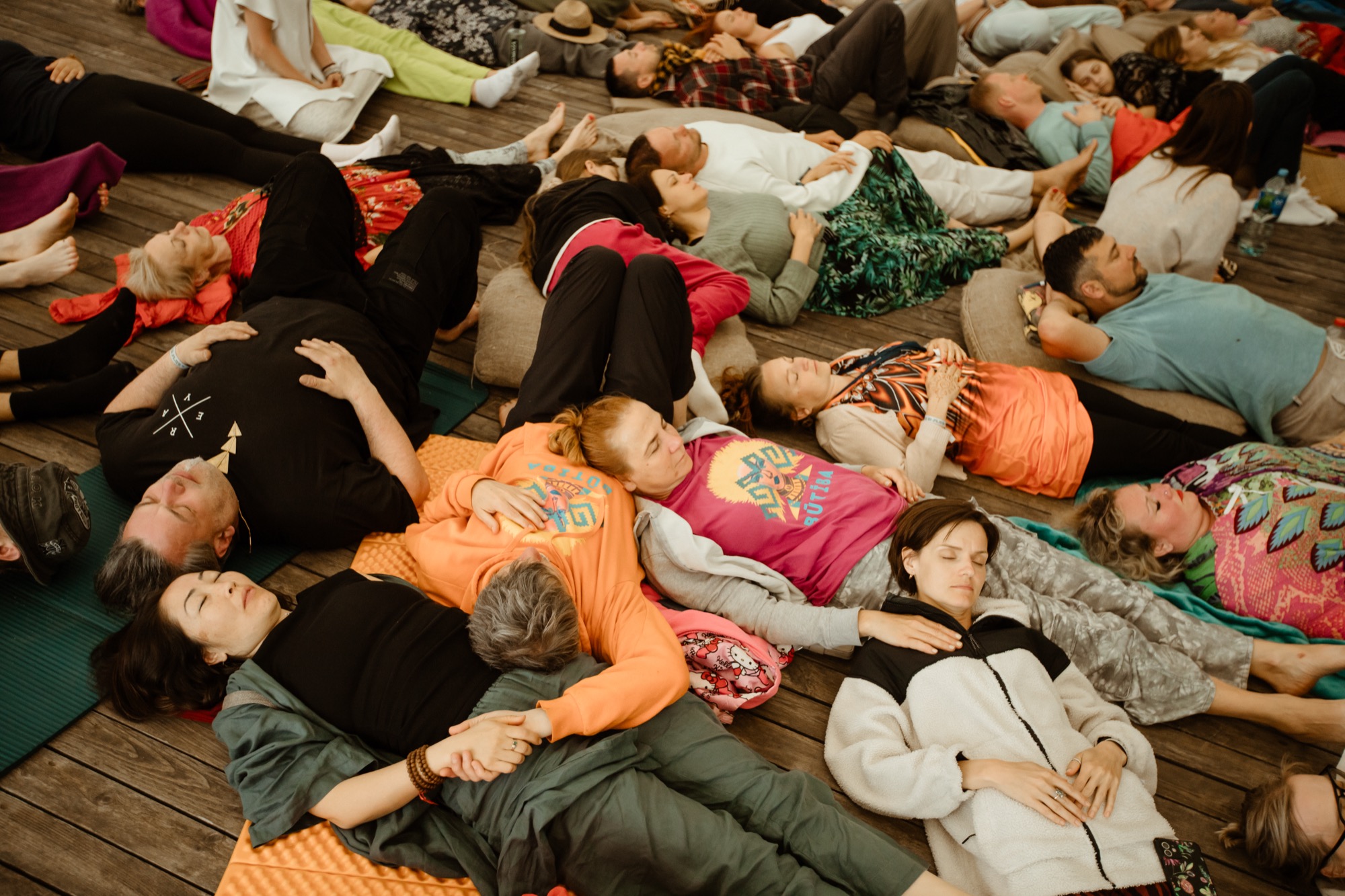 Festival participants lying on the floor during a guided relaxation session at BŪTĪBA Festival 2026