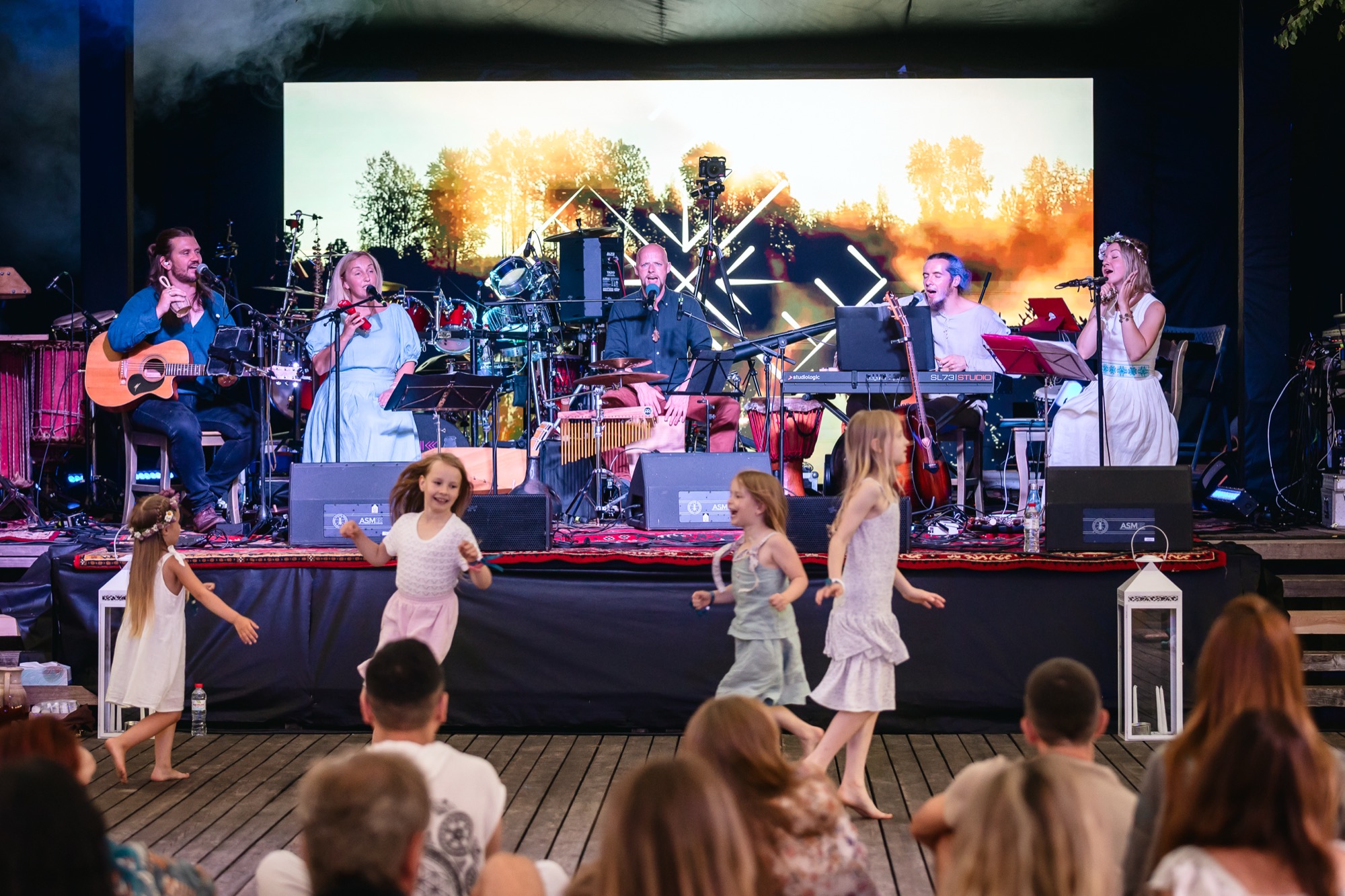 Bērni brīvi dejo Rāmi Riti dzīvās mūzikas pavadījumā BŪTĪBA festivālā 2026, ļaujoties ritmam, priekam un mirkļa burvībai.