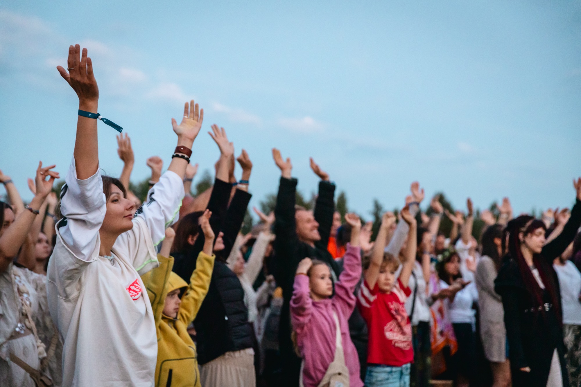 BUTIBA Festival 2026 audience raising their hands together during an outdoor music and movement gathering