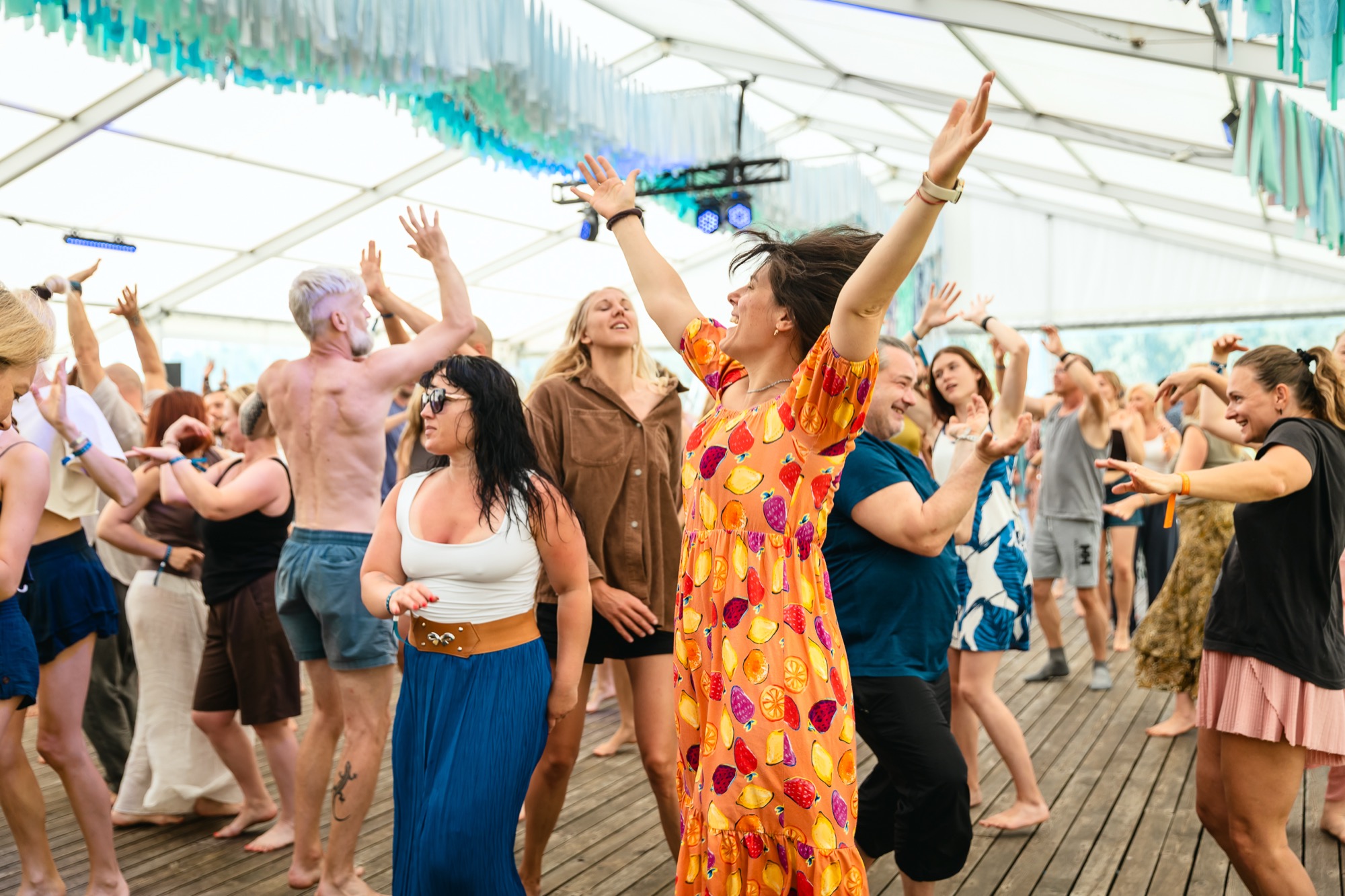 Festival participants raising their arms and dancing together during an ecstatic dance workshop at BŪTĪBA Festival 2026