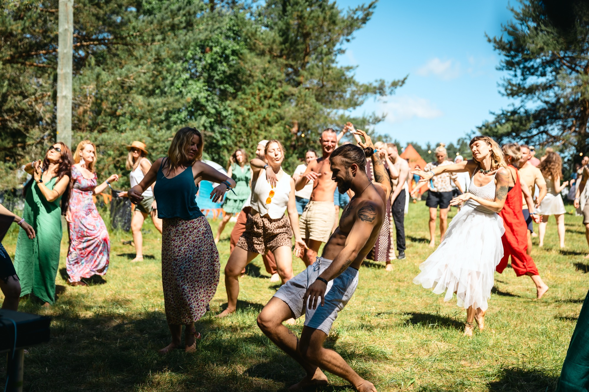 Festival participants dancing freely together outdoors during a movement workshop at BŪTĪBA Festival 2026