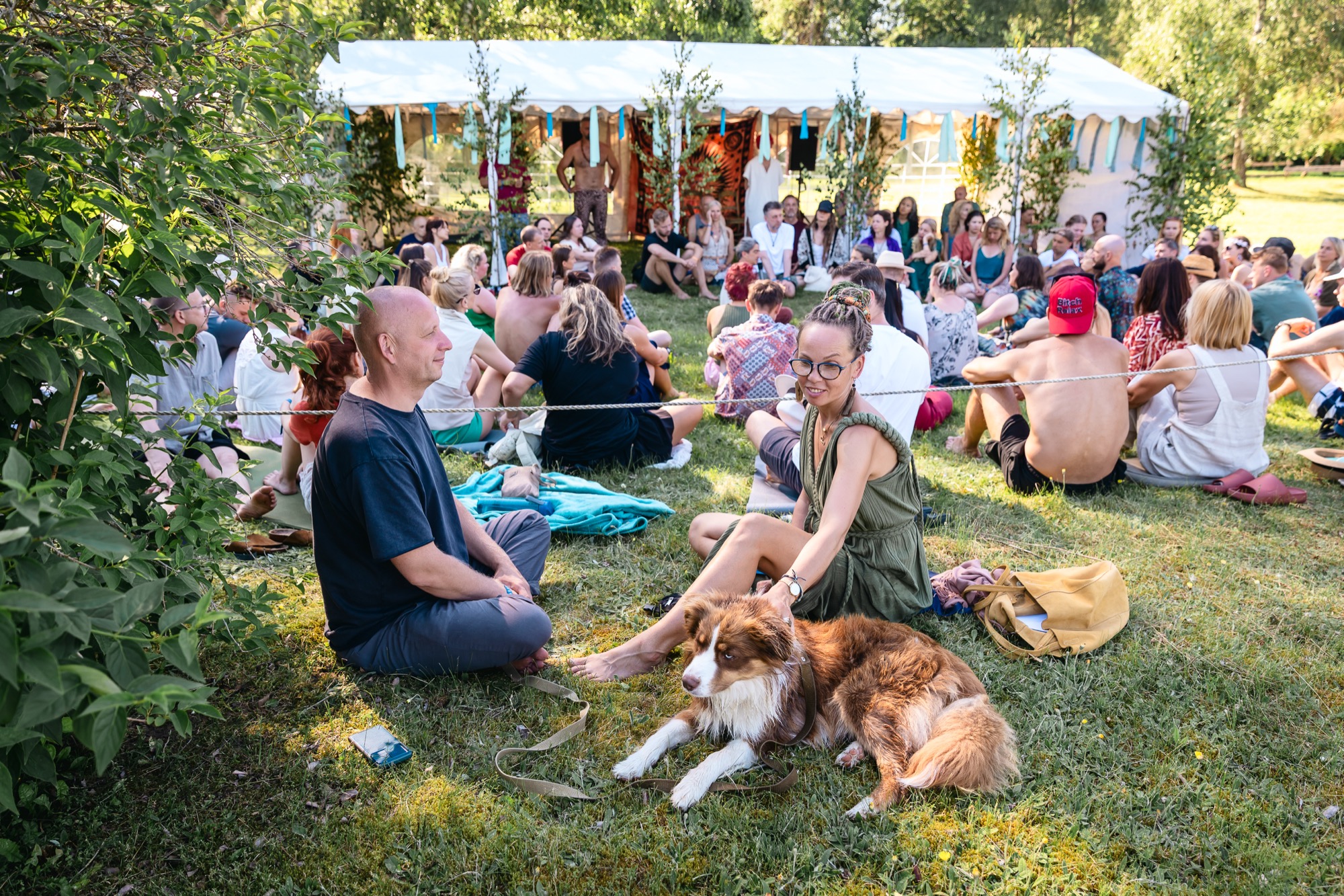 Festival participants sitting together in a circle during an outdoor community workshop at BŪTĪBA Festival 2026
