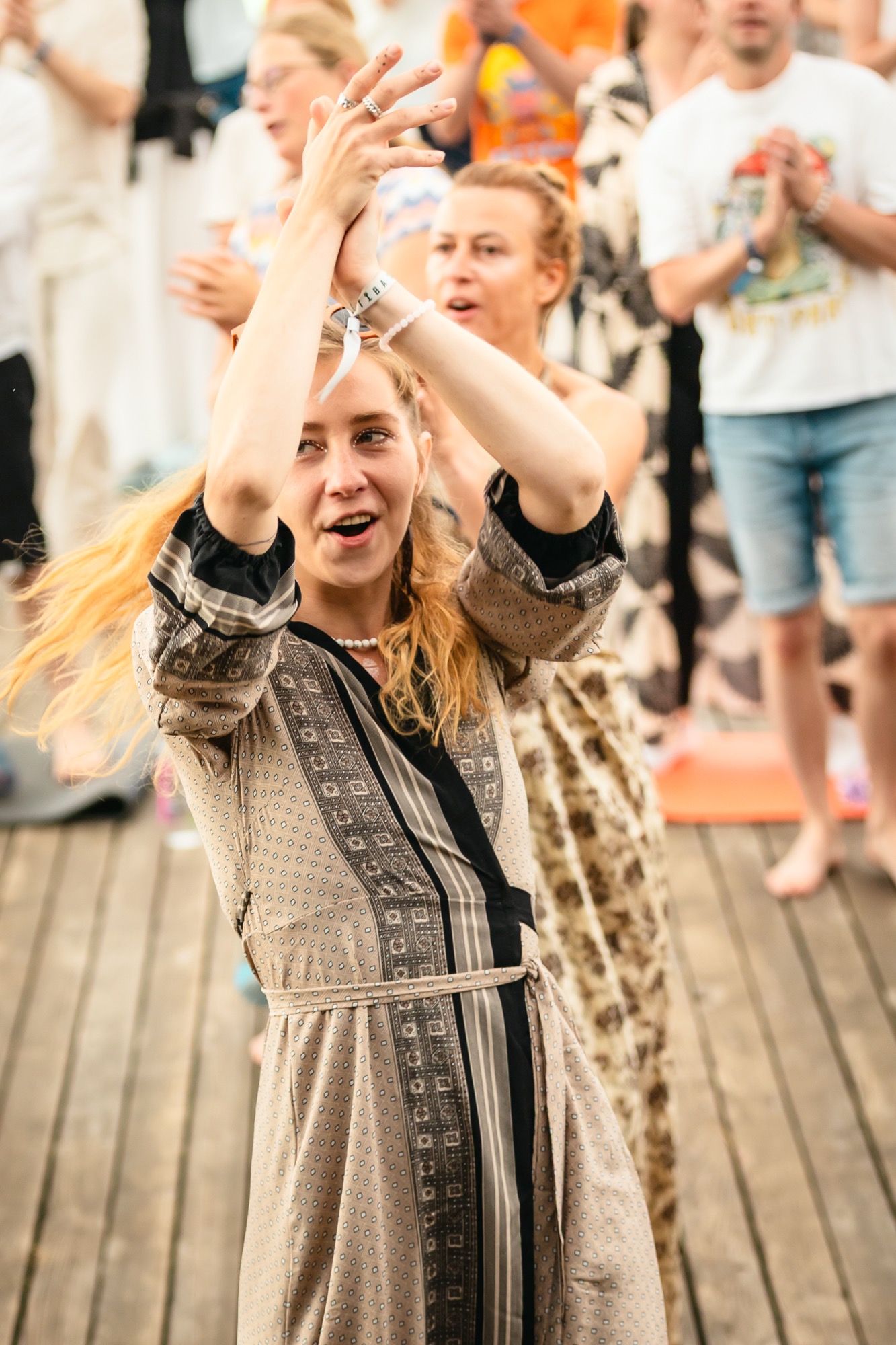 Joyful woman raising her arms and dancing at BUTIBA Festival 2026, surrounded by music, movement and vibrant festival energy