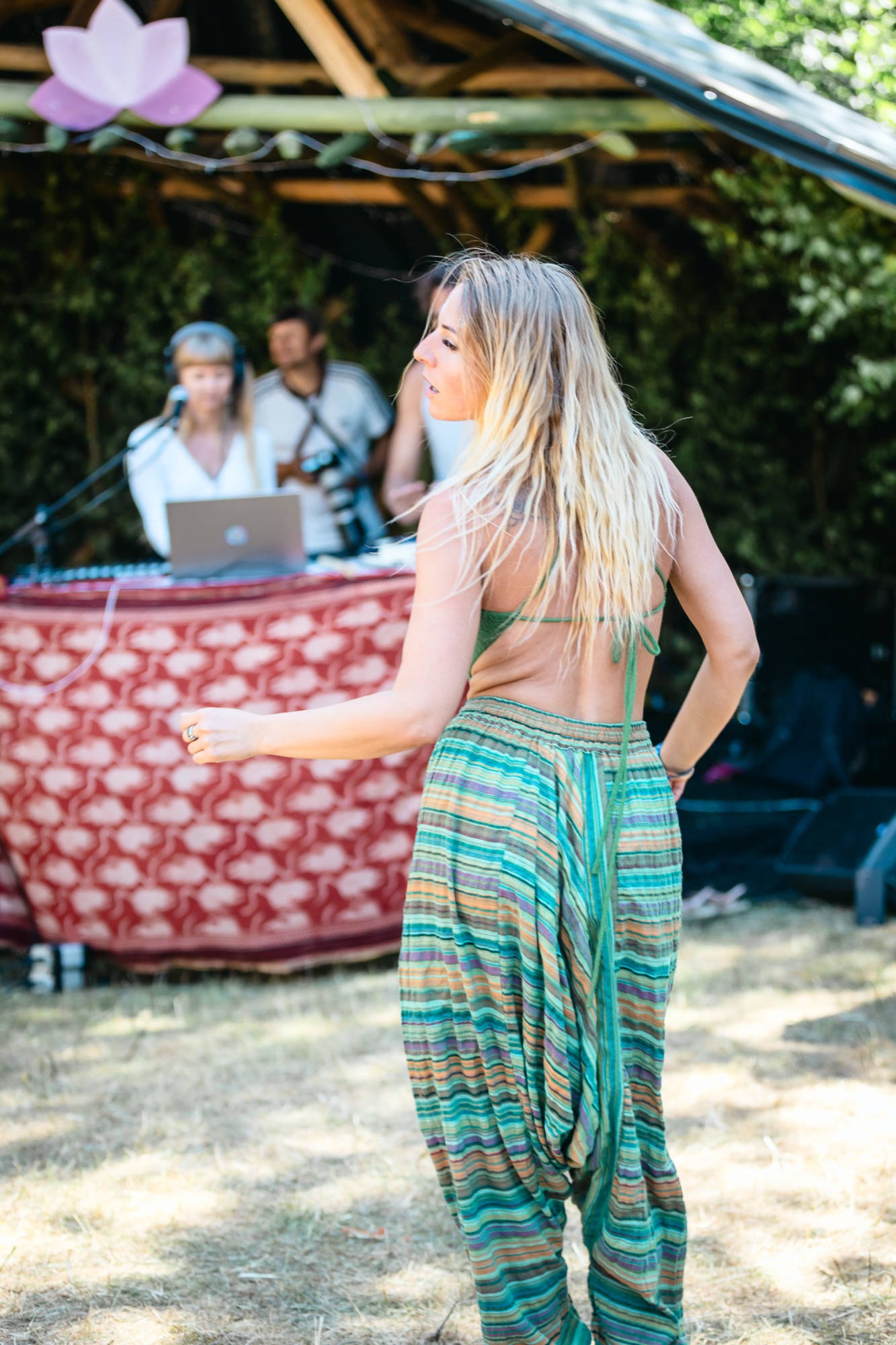 Woman dancing near the outdoor DJ booth during a daytime ecstatic dance session at BUTIBA Festival 2026