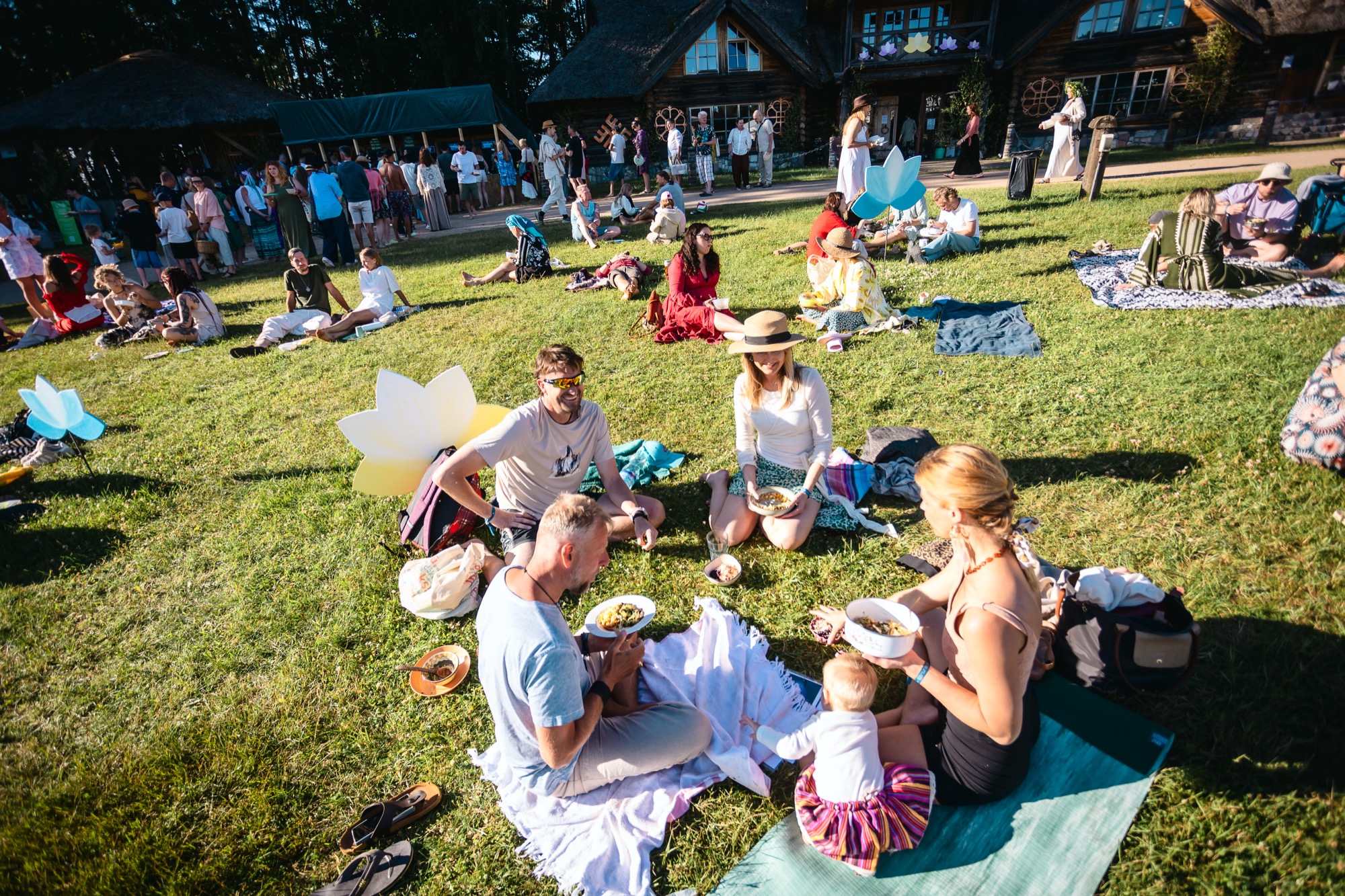 Festival-goers sharing a picnic on the grass at BŪTĪBA Festival 2026