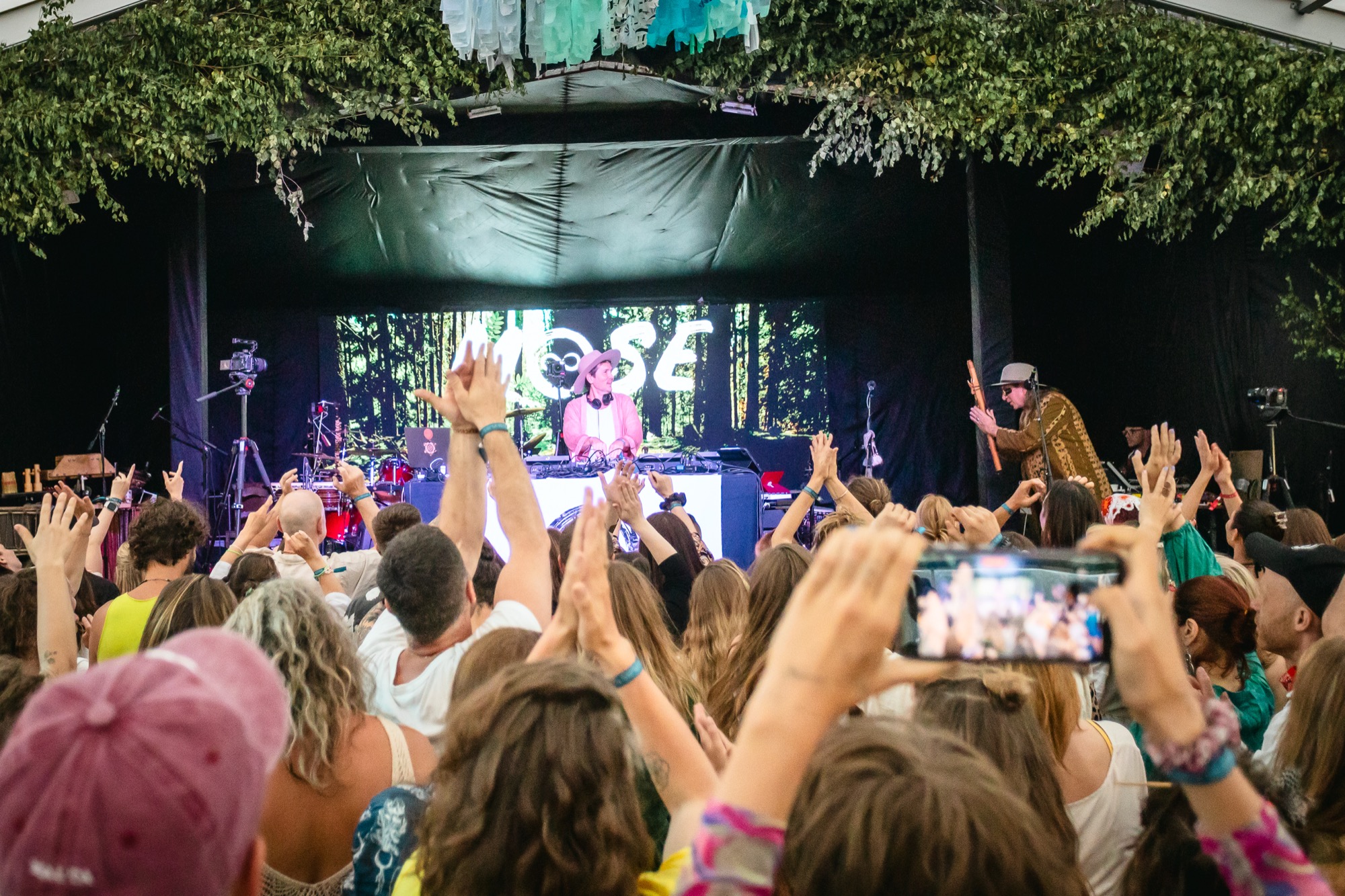 Festival audience raising their hands during a live music performance of MOSE and Kailash Kokopelli at BŪTĪBA Festival 2026