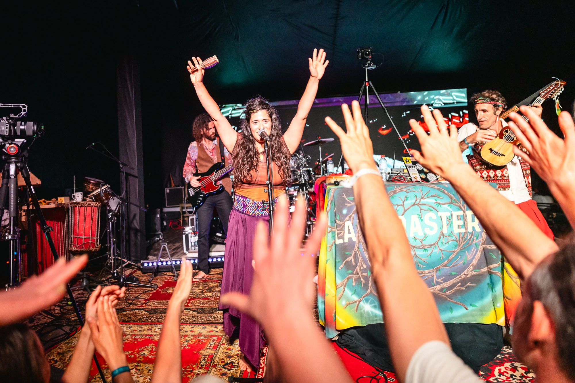 La Forasteria performing live at BŪTĪBA Festival 2026 as the audience raises their hands and cheers
