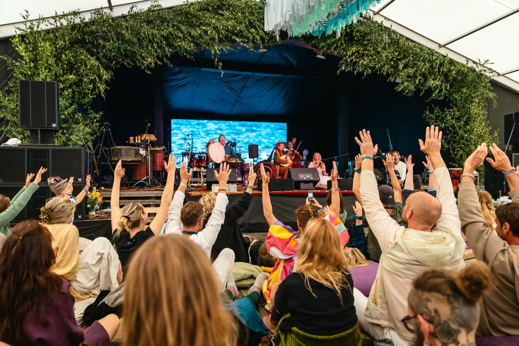 Festival audience raising their hands during a live world music performance at BŪTĪBA Festival 2026