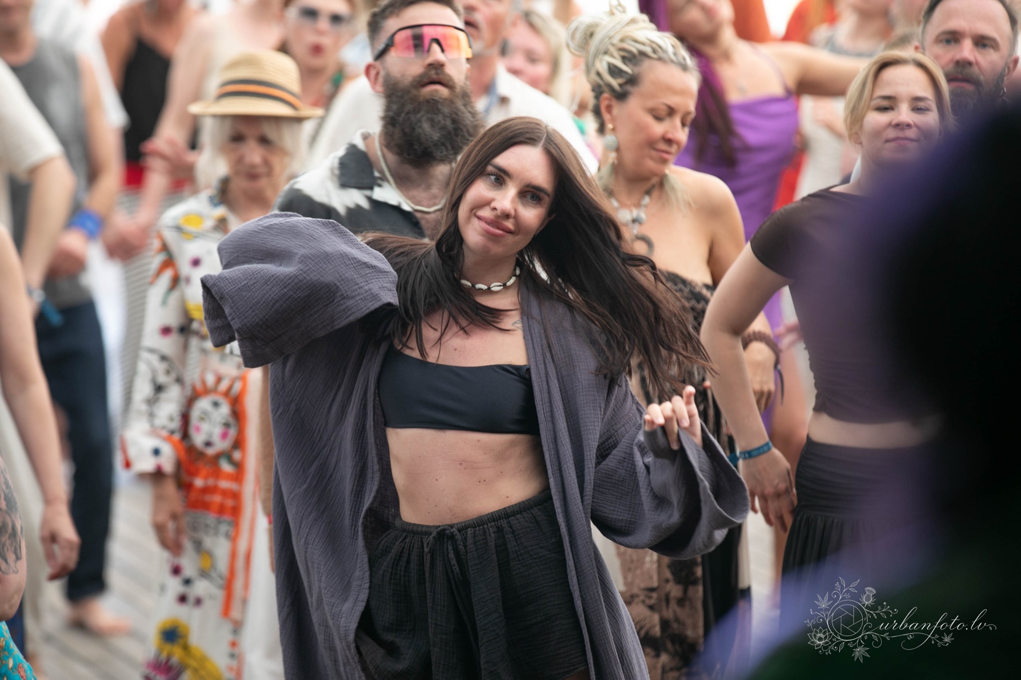 Woman dancing freely among festival-goers during a dance gathering at BŪTĪBA Festival 2026