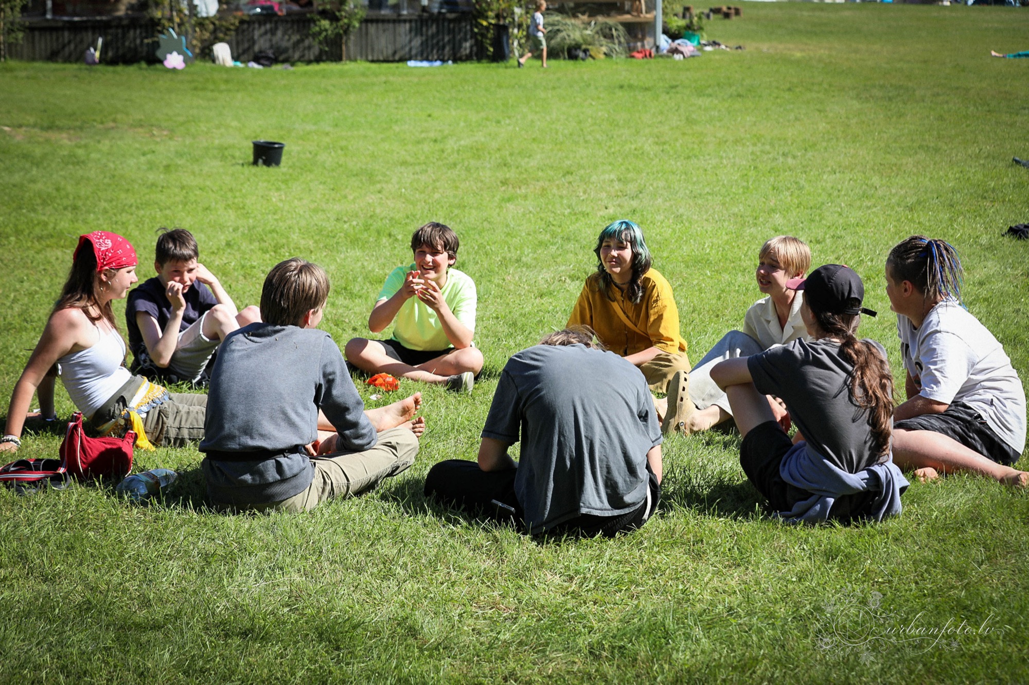 Children and teenagers gathering outdoors on the grass at BUTIBA Festival 2026, a family-friendly summer solstice festival celebrating Latvian Jāņi and Līgo traditions