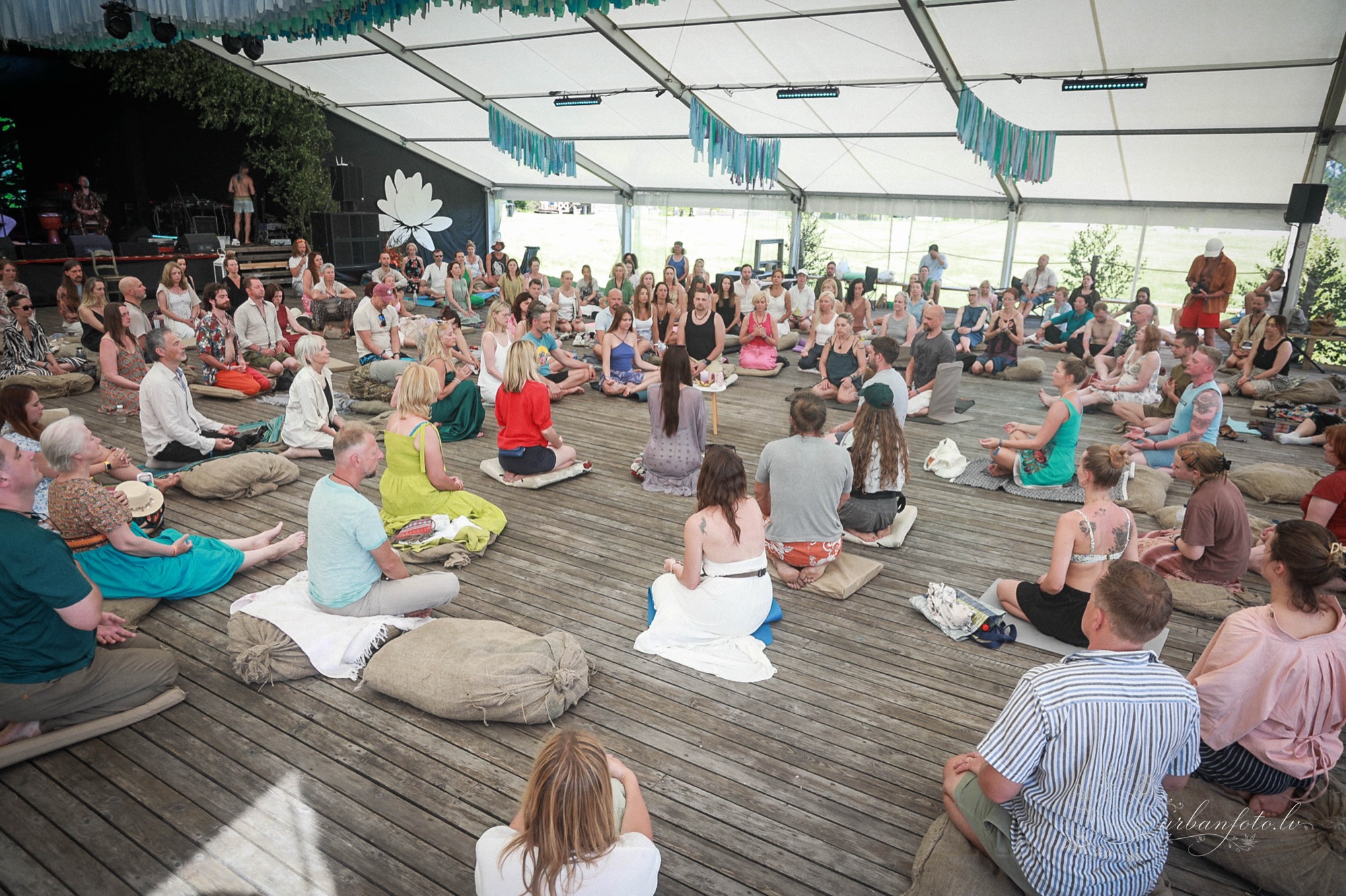 Participants seated in a circle during a group workshop inside the main tent at BŪTĪBA Festival 2026