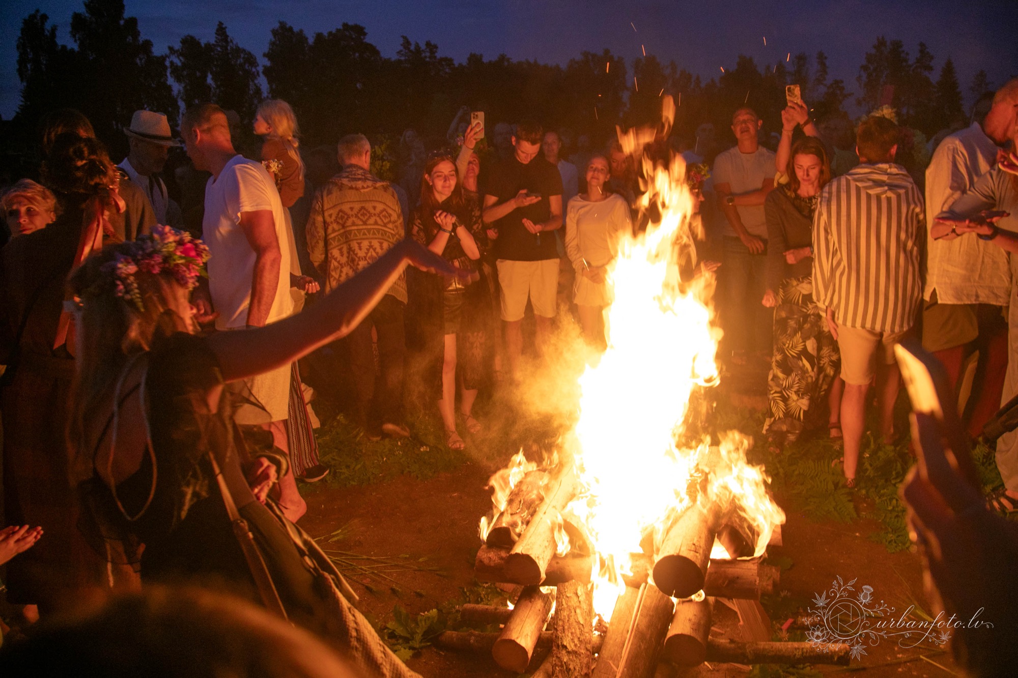Festival-goers dancing and celebrating around a bonfire at BŪTĪBA Festival
