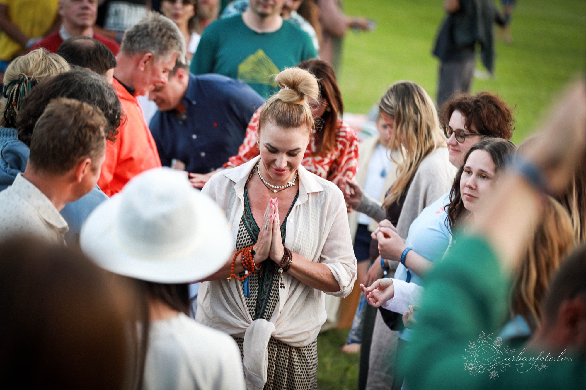 Festival participant with hands joined in a gesture of gratitude during a community gathering at BŪTĪBA Festival 2026